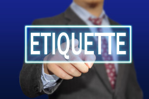 Business concept image of a businessman clicking Etiquette button on virtual screen over blue background